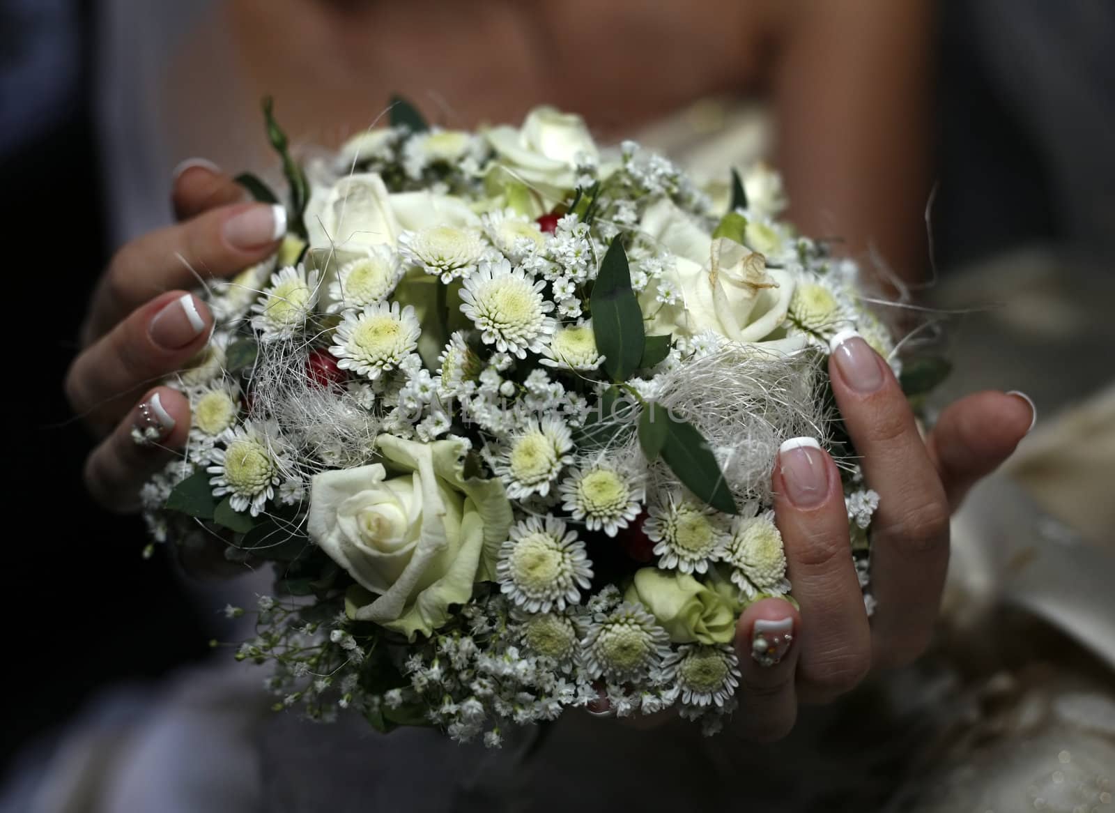 Wedding bouquet from roses and chrysanthemums on a background of a dress