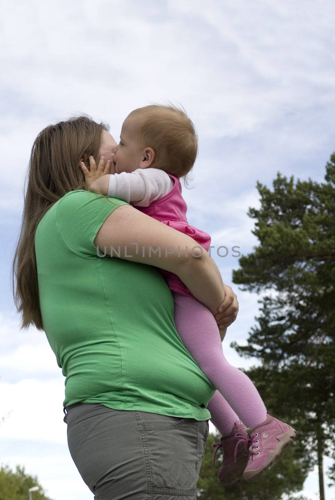 Sweet little toddler girl kissing obese mother.