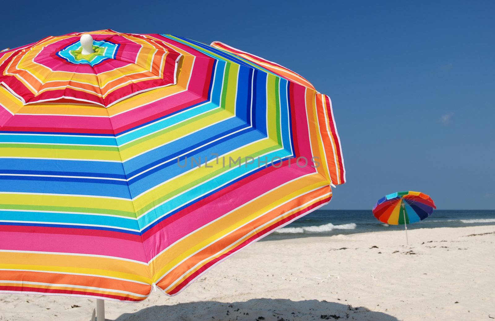 Beach umbrellas on white sand beach.