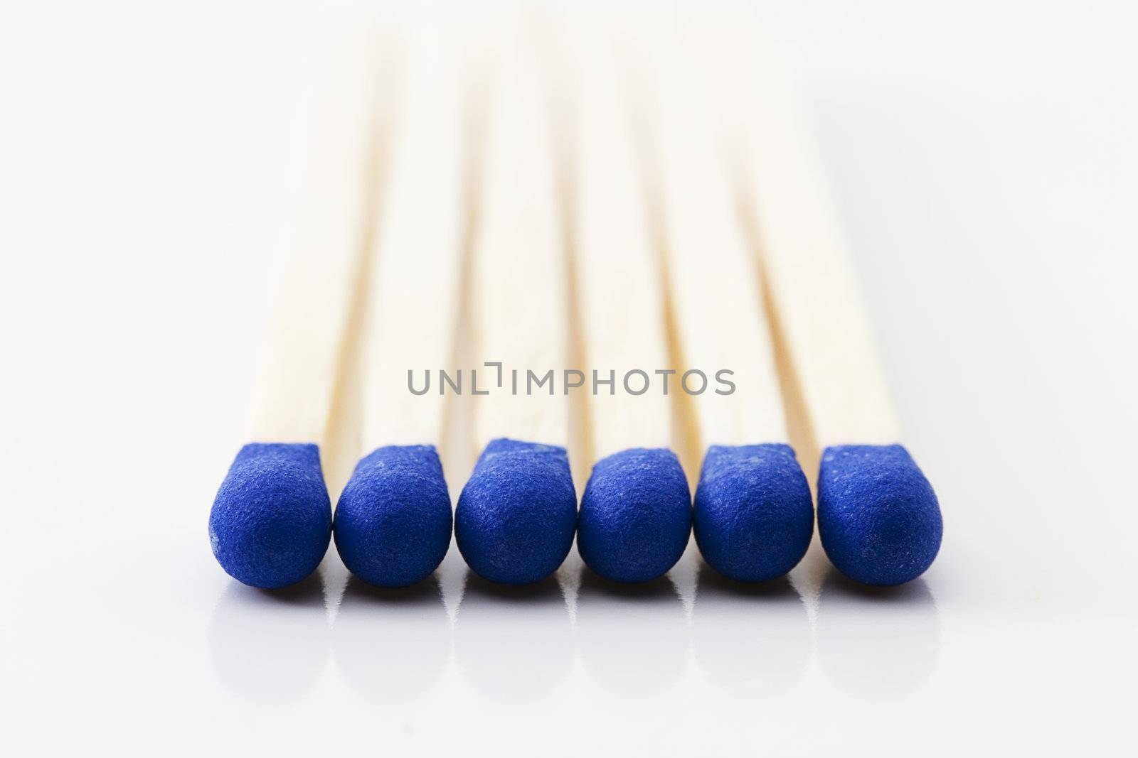 makro of some blue match heads on white background