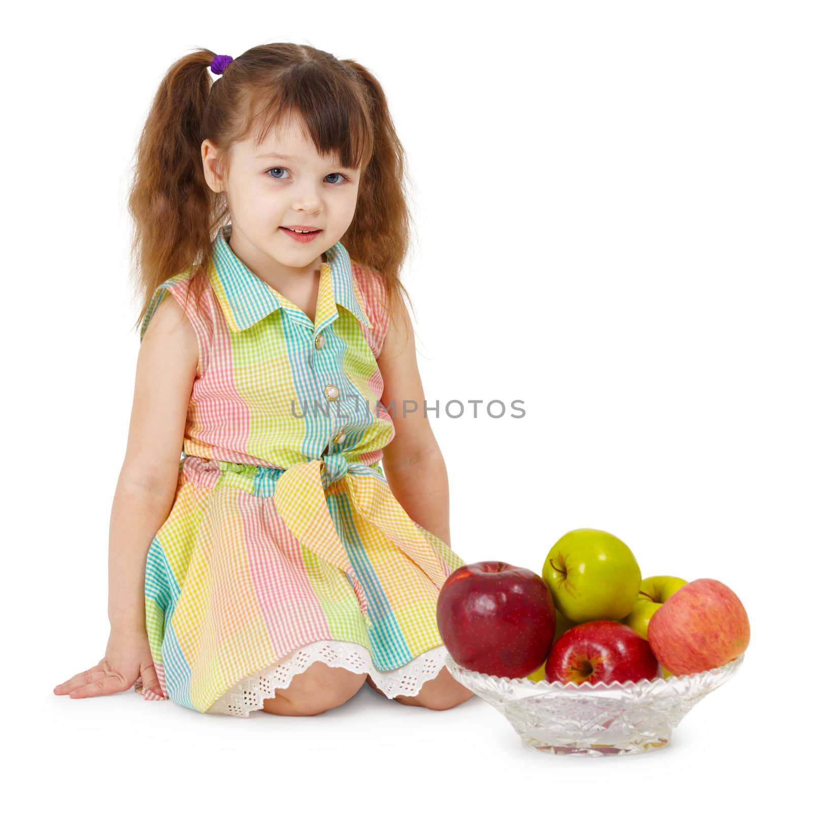 A little girl with a dish filled with apples