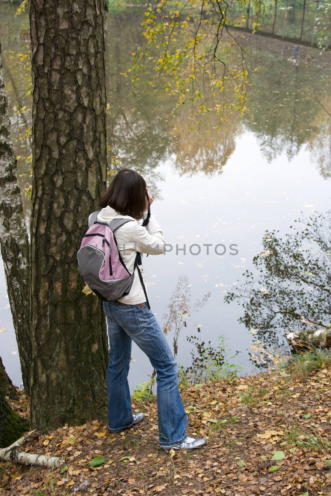 The girl with a backpack costs the person to lake
