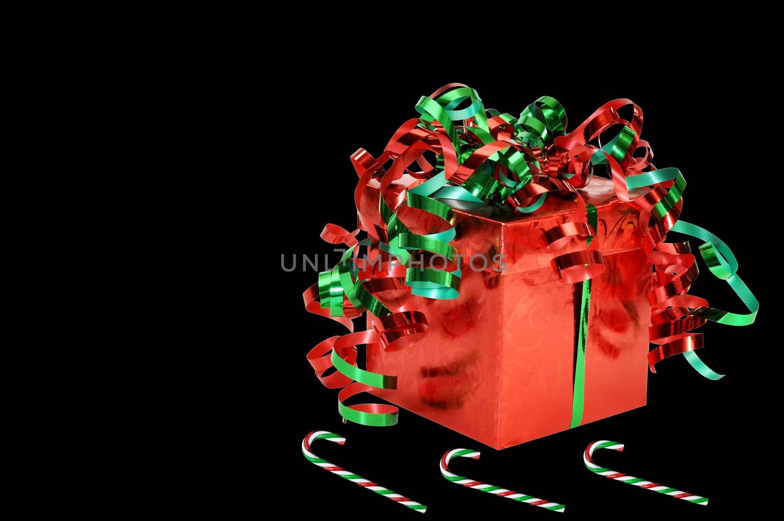 Christmas gift and candy canes isolated on black background.