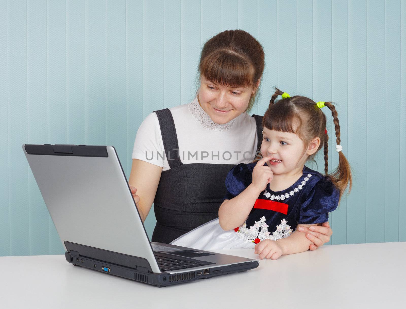 Mother and child playing with a laptop at the table