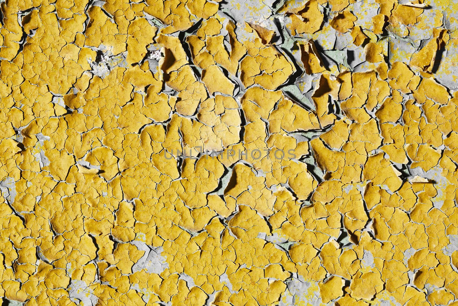 The texture of the old walls covered with peeling yellow paint