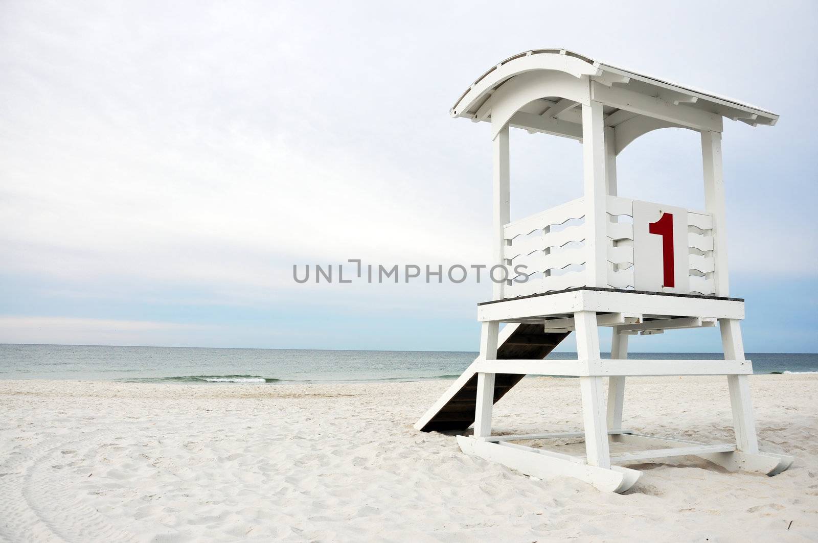 Lifeguard hut on white sand beach.
