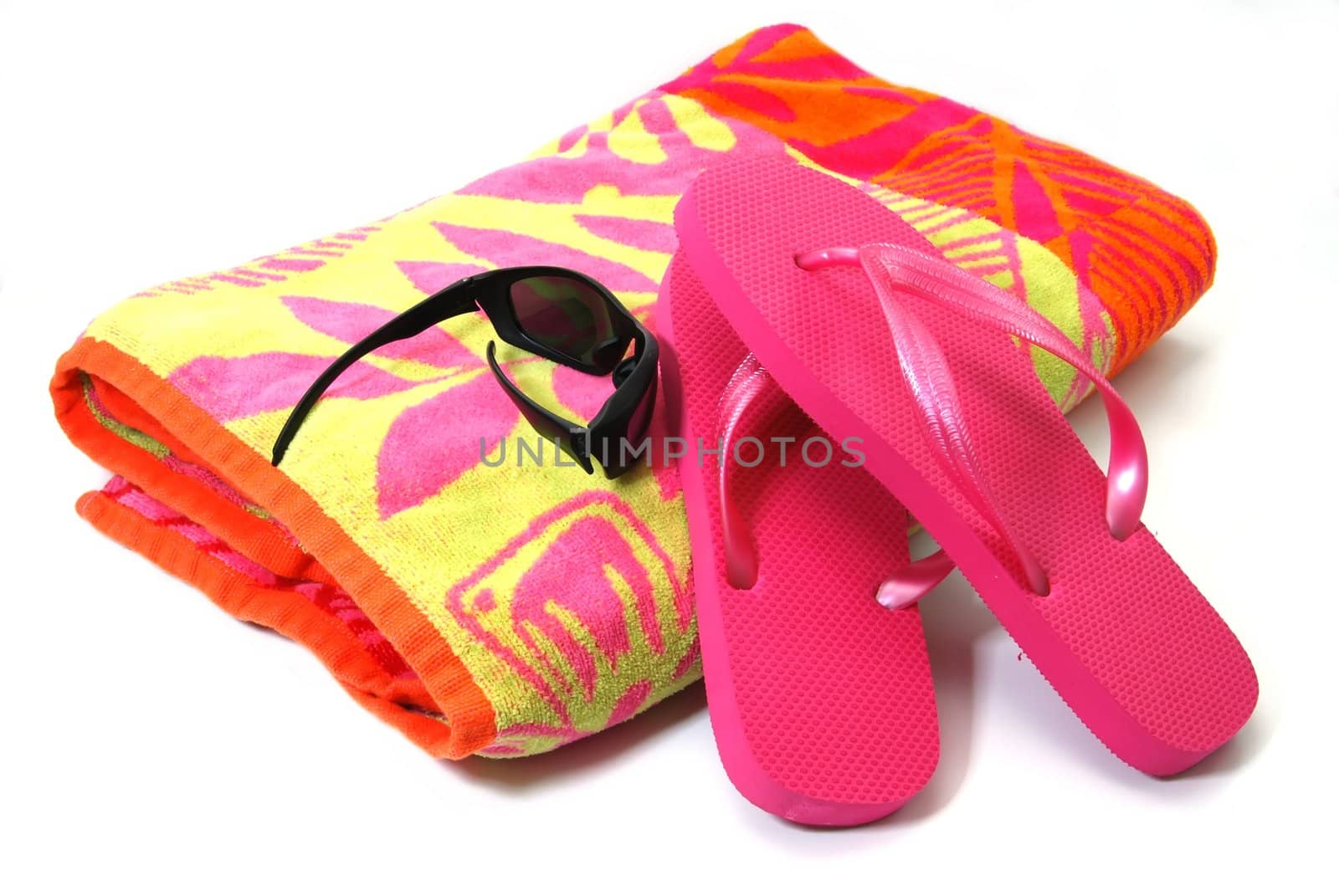 Beach towel, flip flops, and sunglasses isolated on white background.
