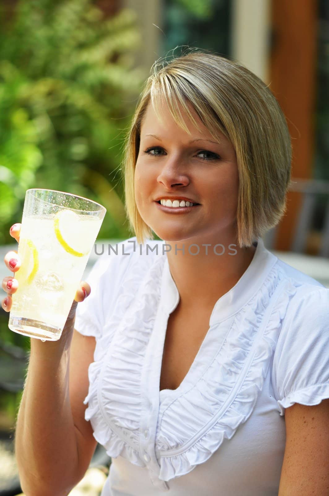 Blond woman with glass of lemonade.