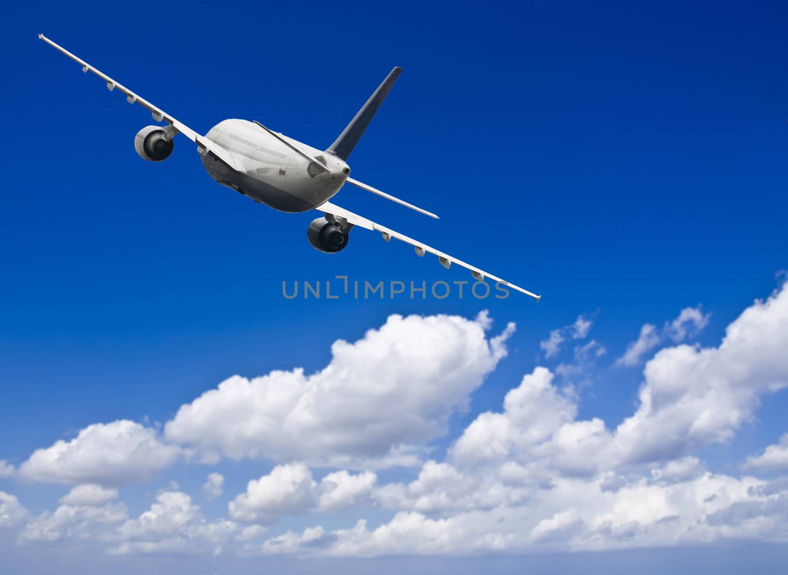 Civil aircraft travelling in deep blue skies with some cloud