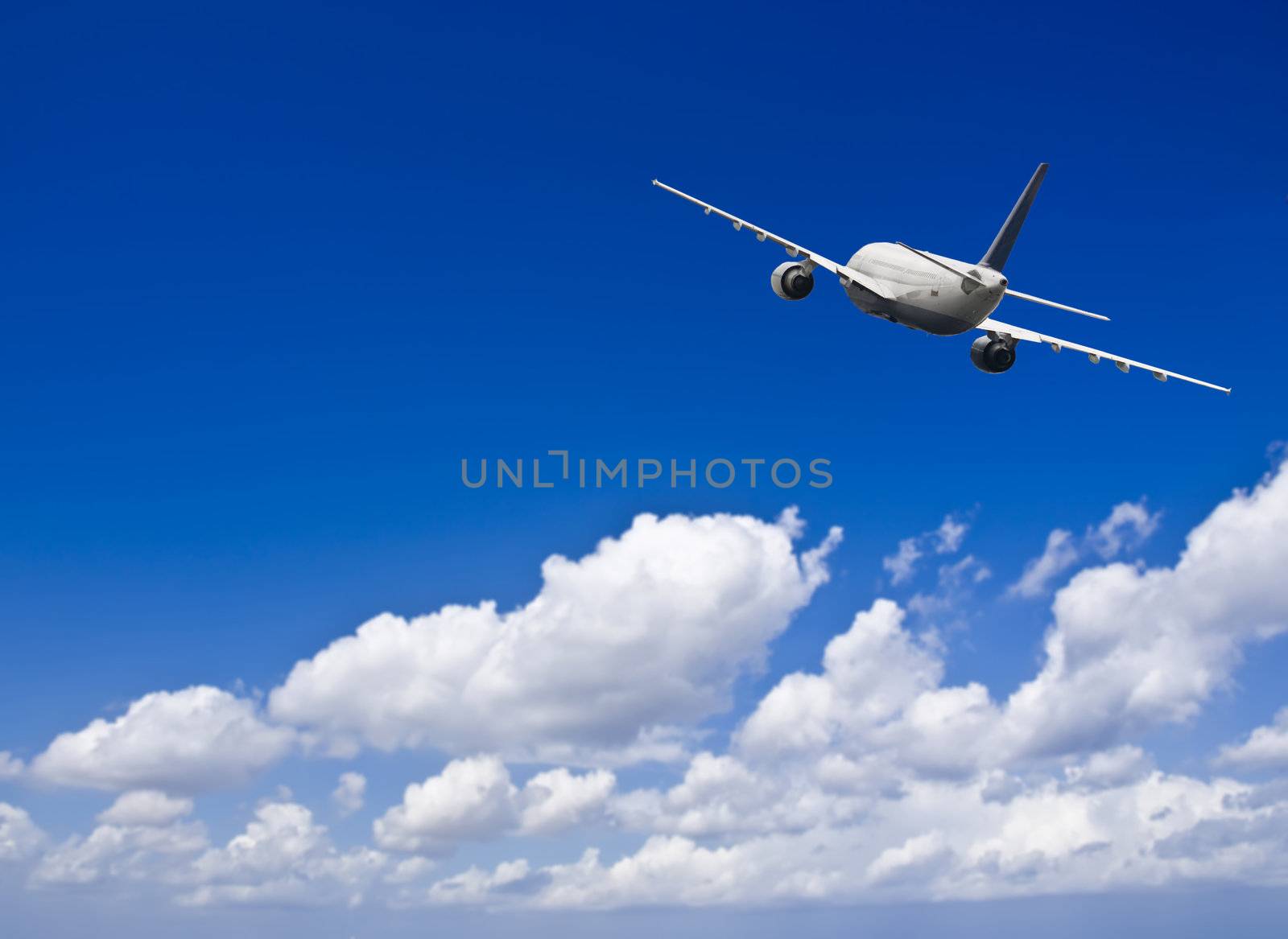 Civil aircraft travelling in deep blue skies with some cloud