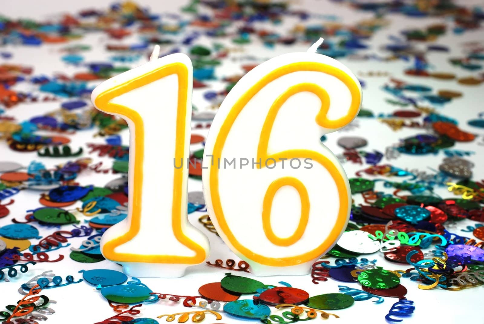 Number 16 celebration candle with confetti.