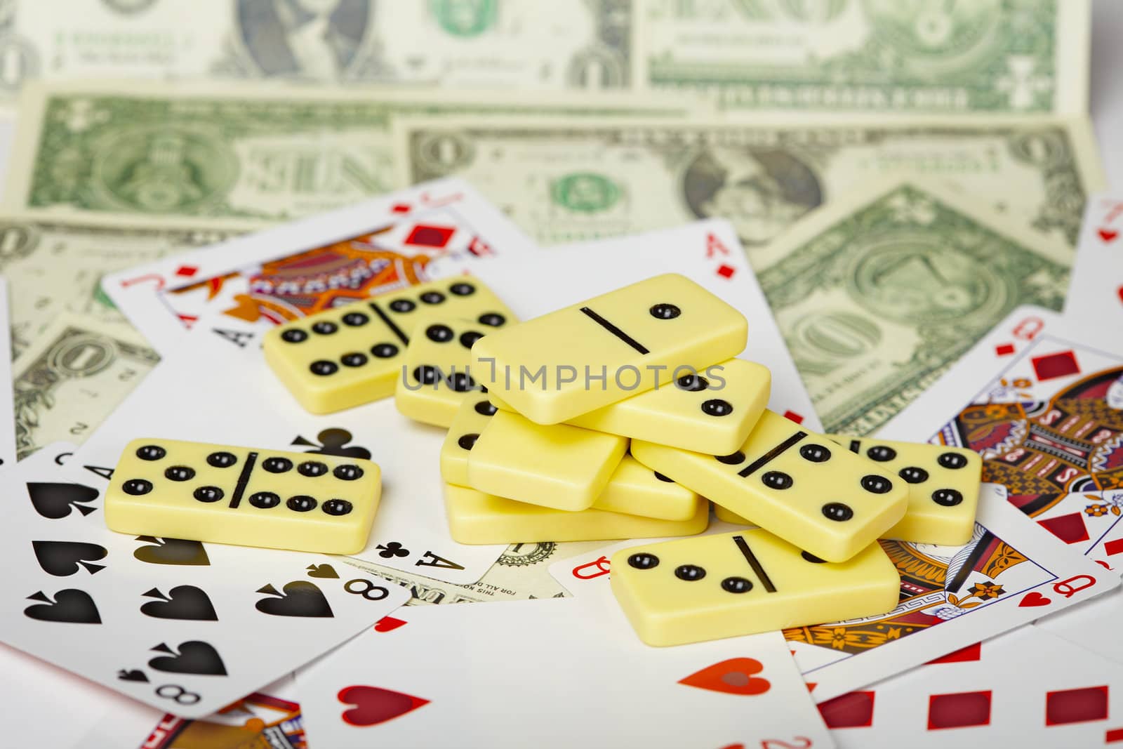 Several dominoes against a background of cards and money