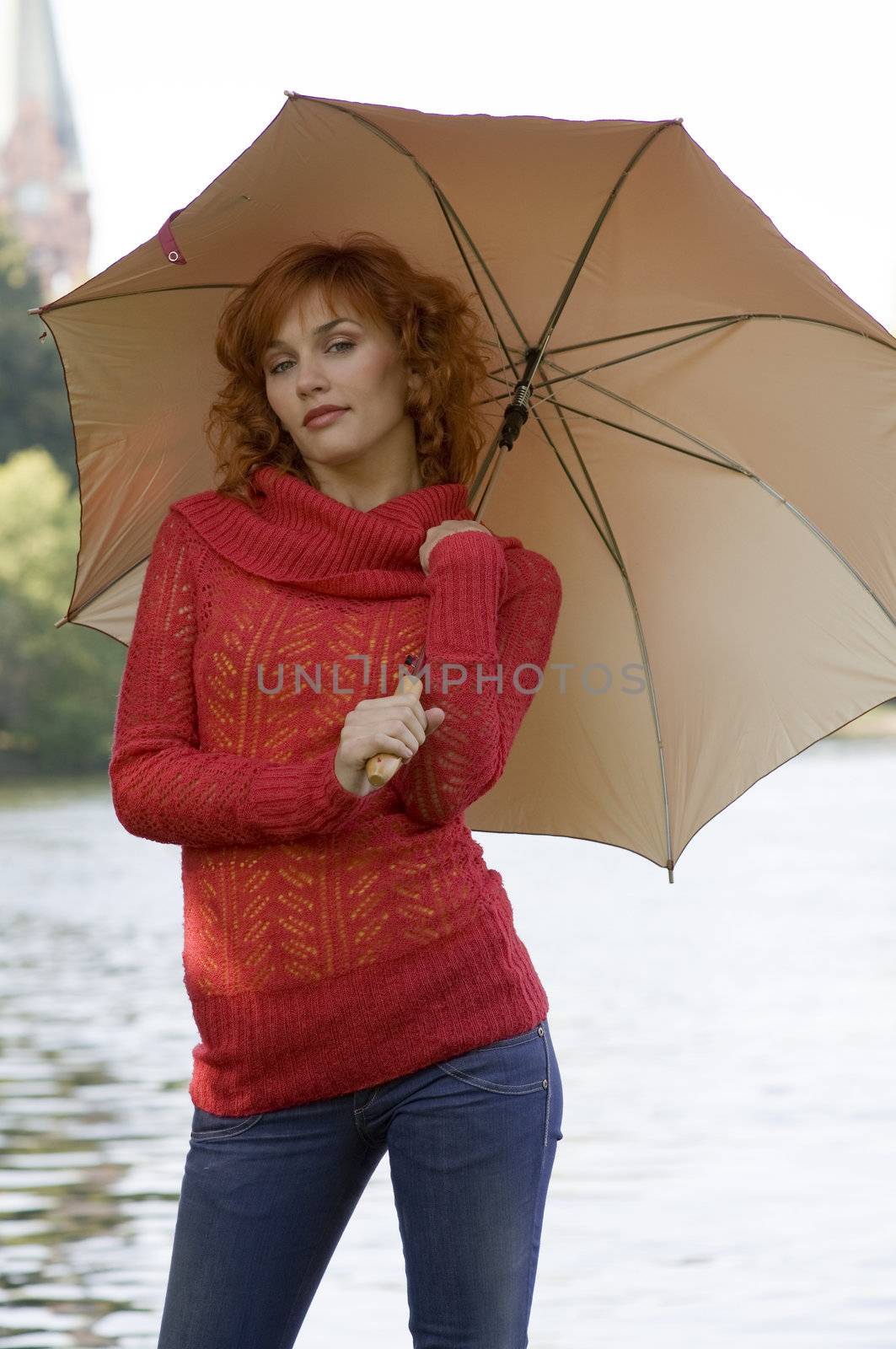 cute red haired girl near river with umbrella and red pullover