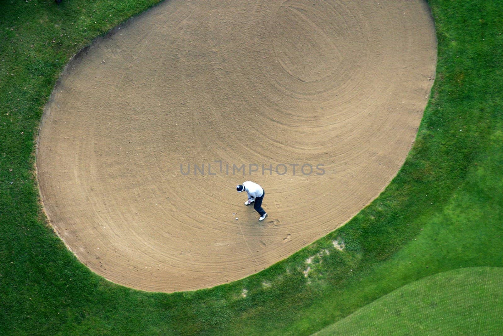 Golfer trying to put the ball out of the sand