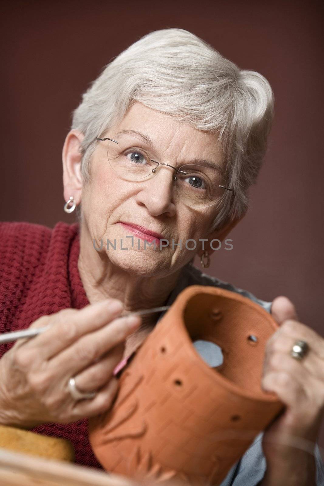 Senior woman working on a clay sculpture