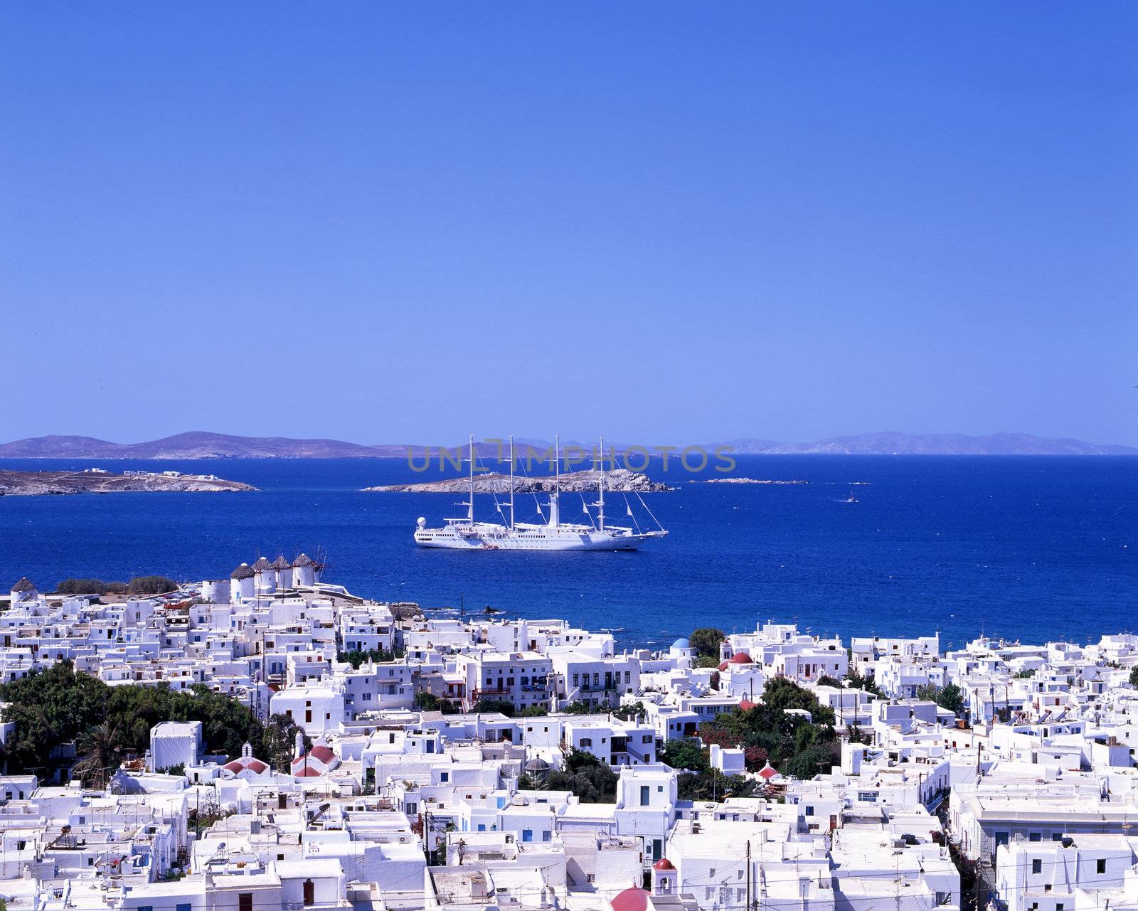 A large white sailing boat going into the port of Mykonos, a Greek island