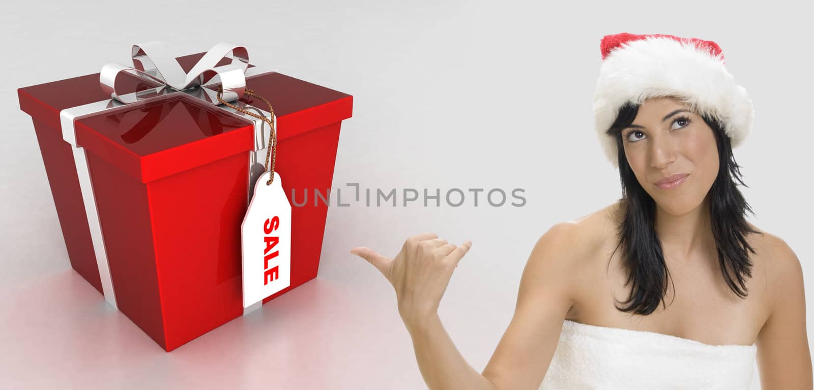 sexy brunette woman wearing santa cap and indicating towards the gift