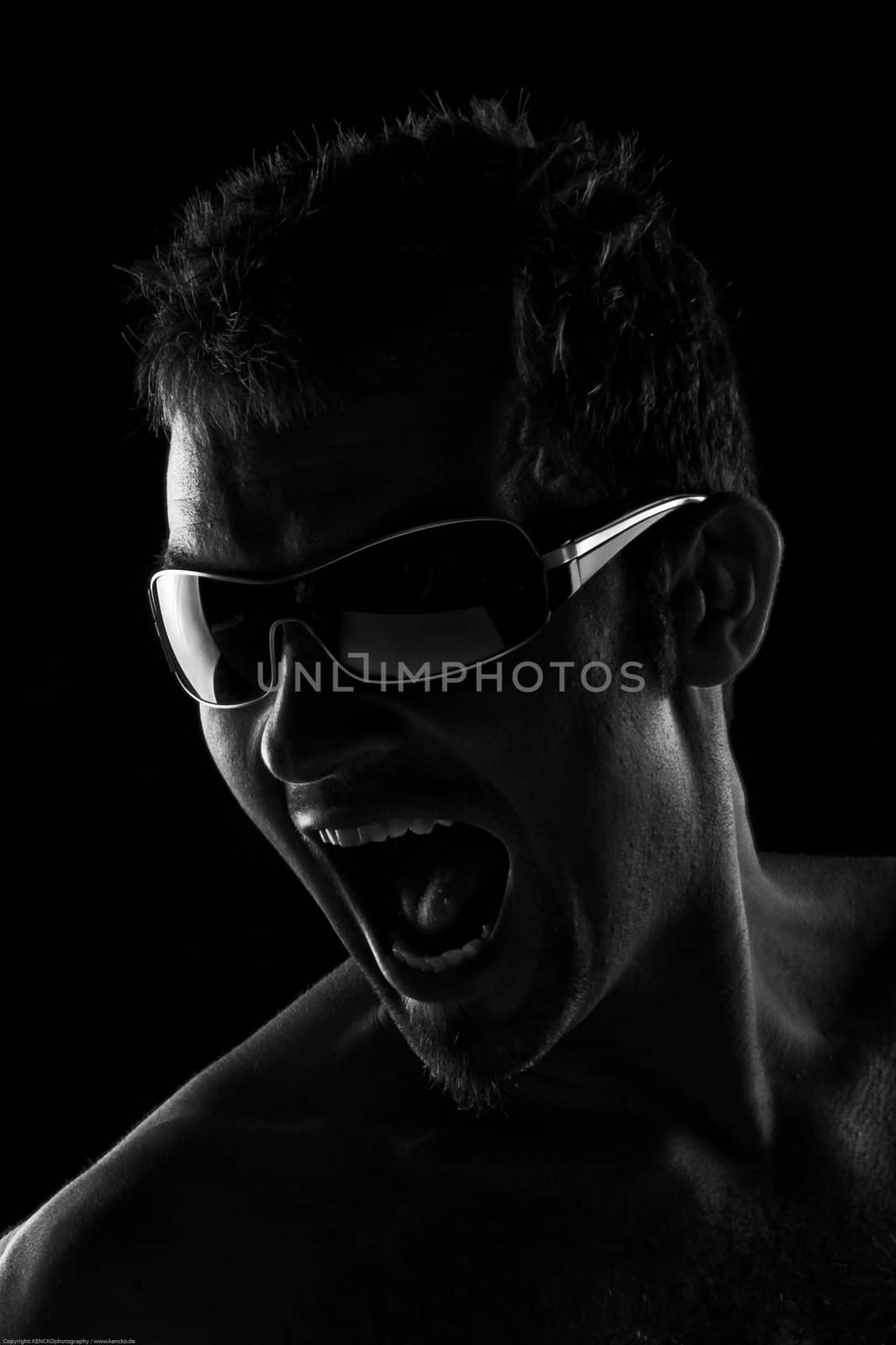 Portrait Of A Handsome Young Man Screaming And Wearign Sunglasses