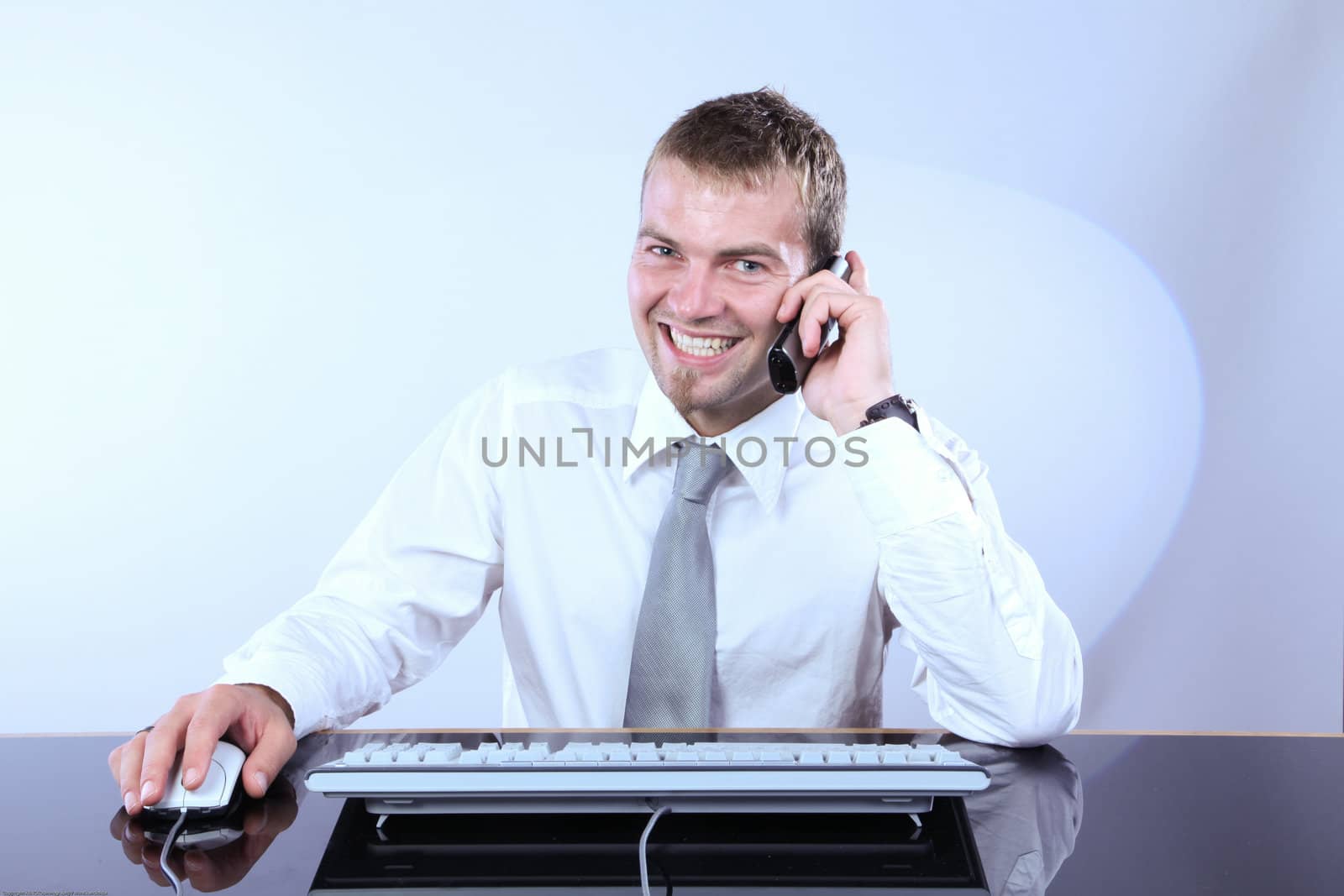 Cheerful Corporate Man Talking On The Phone And Working On Computer