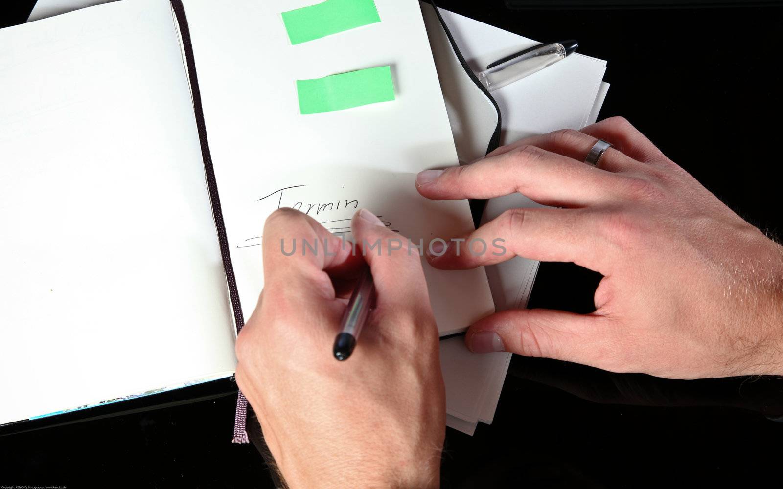 Closeup Photo Of A Man Taking Notes In His Agenda
