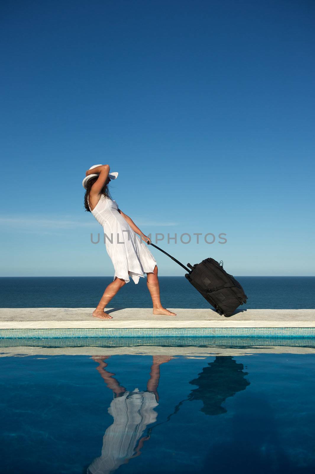 Traveler with heavy baggage walking on a swimming pool with sea view in Arraial d'Ajuda, Bahia, Brazil, Nikon D3S, Nikon AF-S 24-70, RAW shooting.