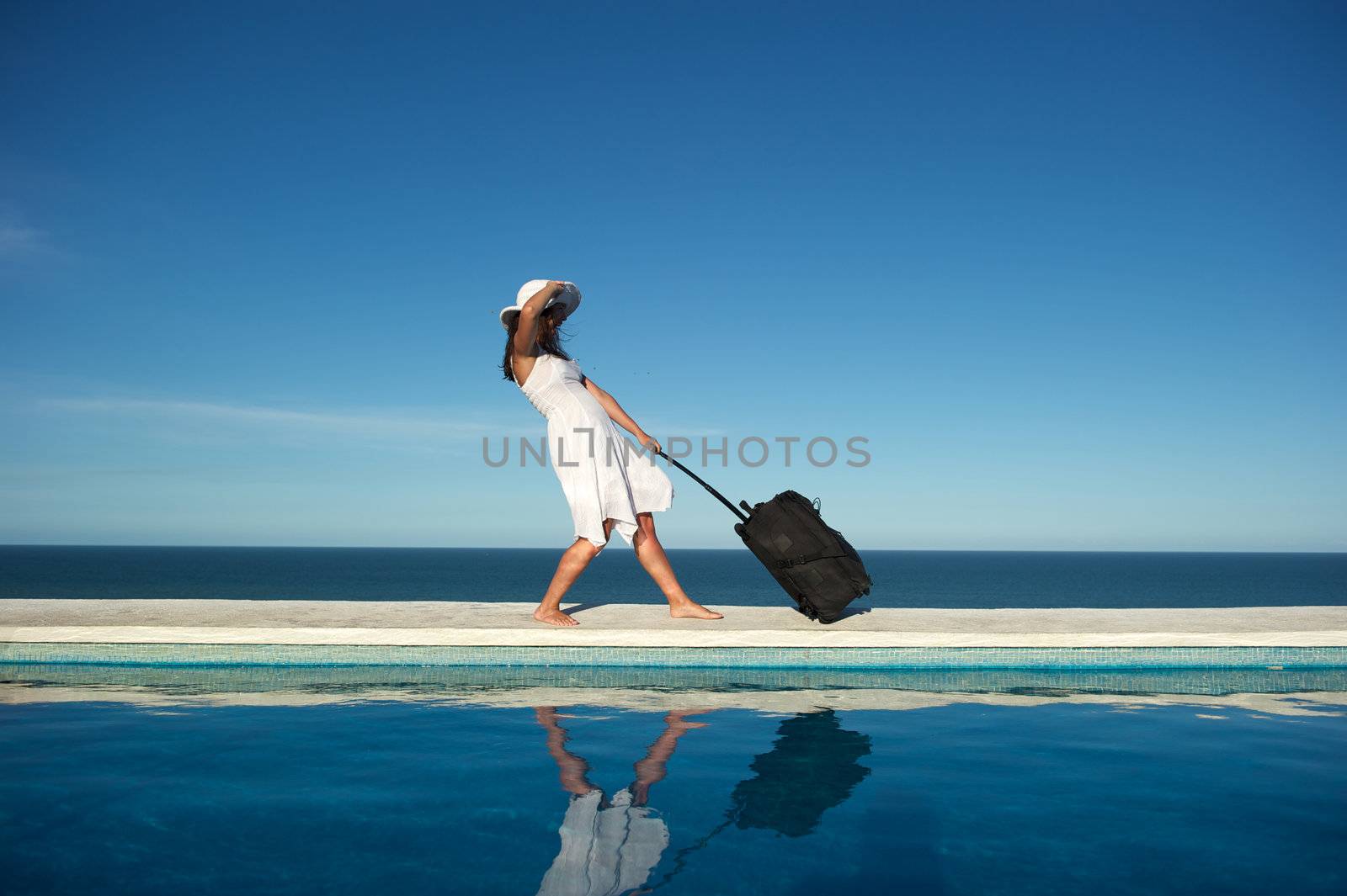 Traveler with heavy baggage walking on a swimming pool with sea view in Arraial d'Ajuda, Bahia, Brazil, Nikon D3S, Nikon AF-S 24-70, RAW shooting.