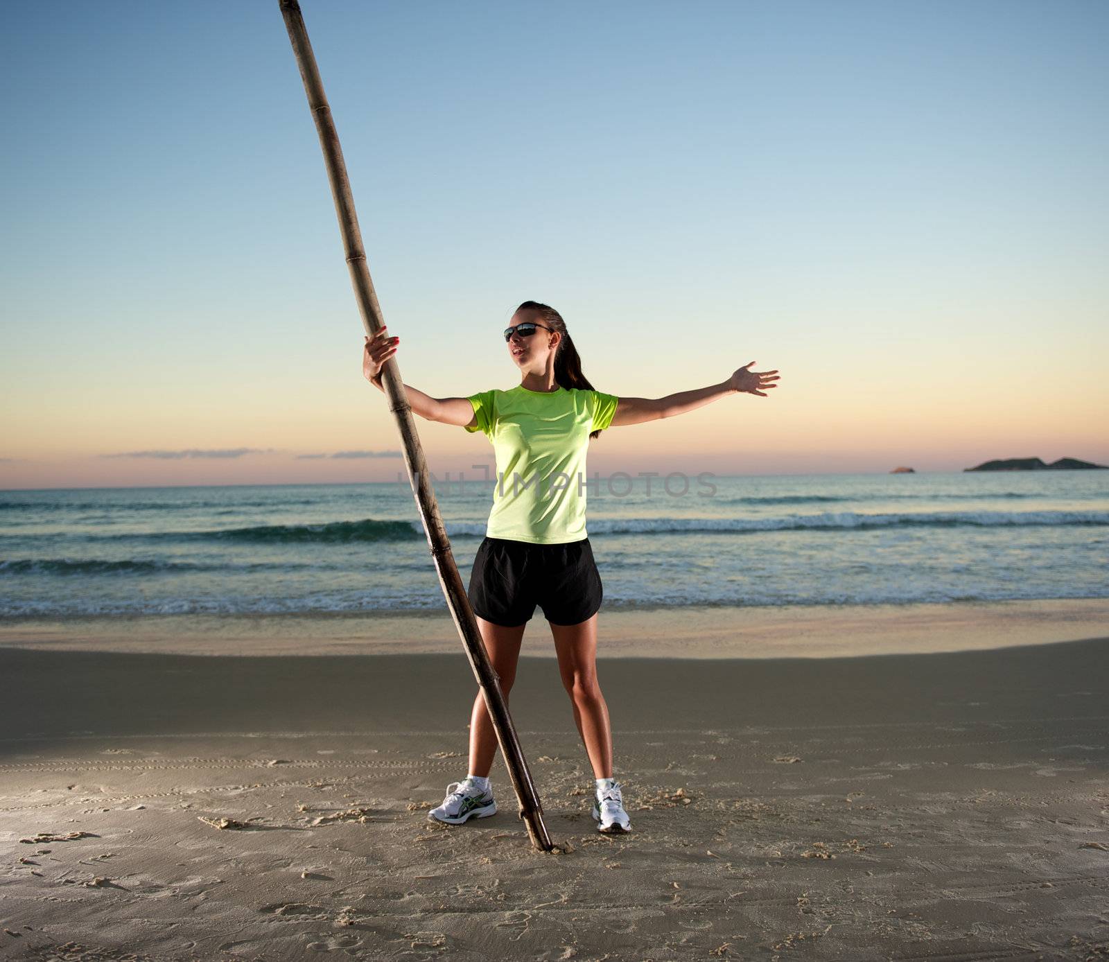 Woman doing exercises during sunset with sunglasses in Florianopolis, Santa Catarina, Brazil