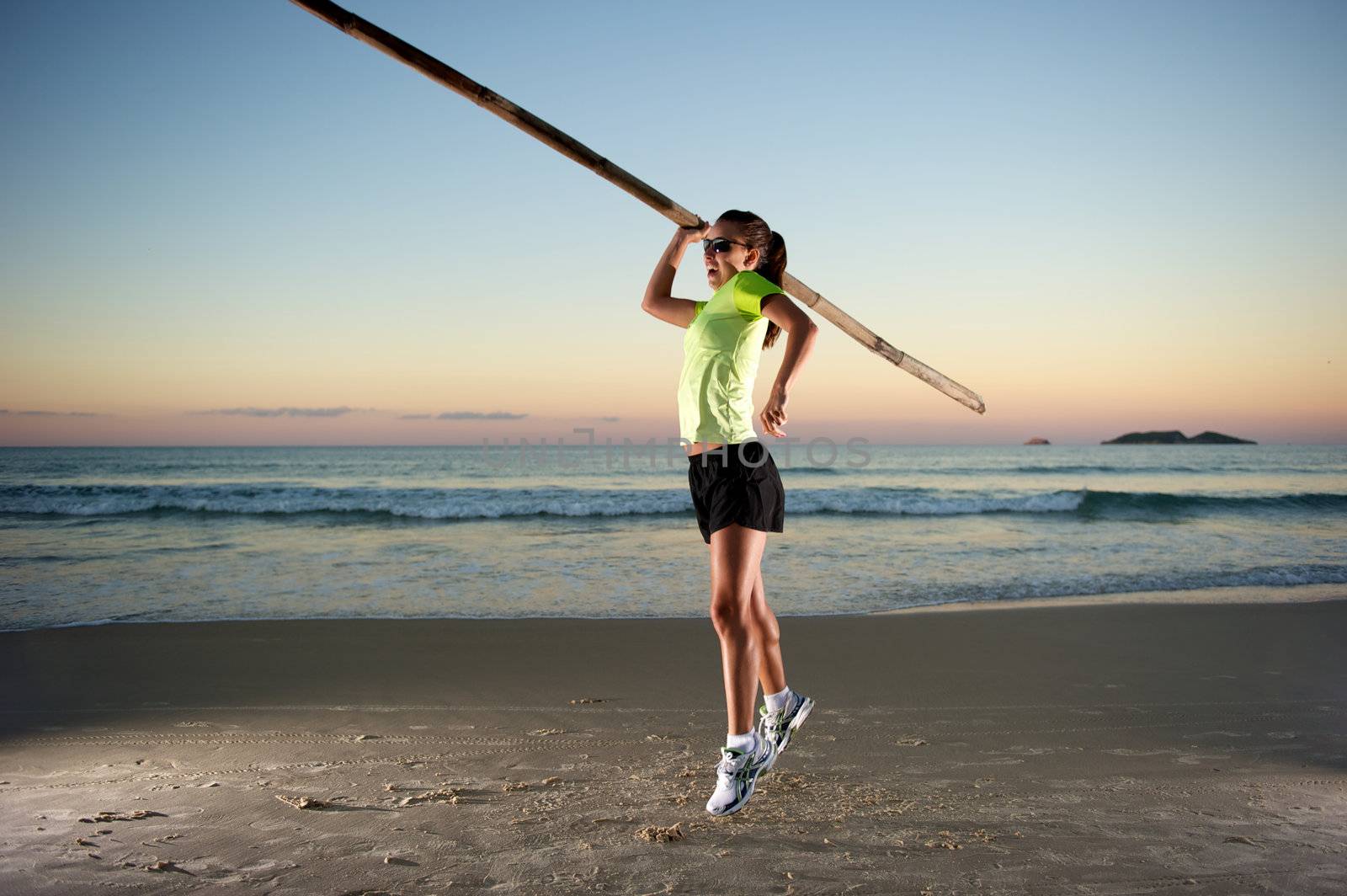 Woman doing exercises during sunset with sunglasses in Florianopolis, Santa Catarina, Brazil