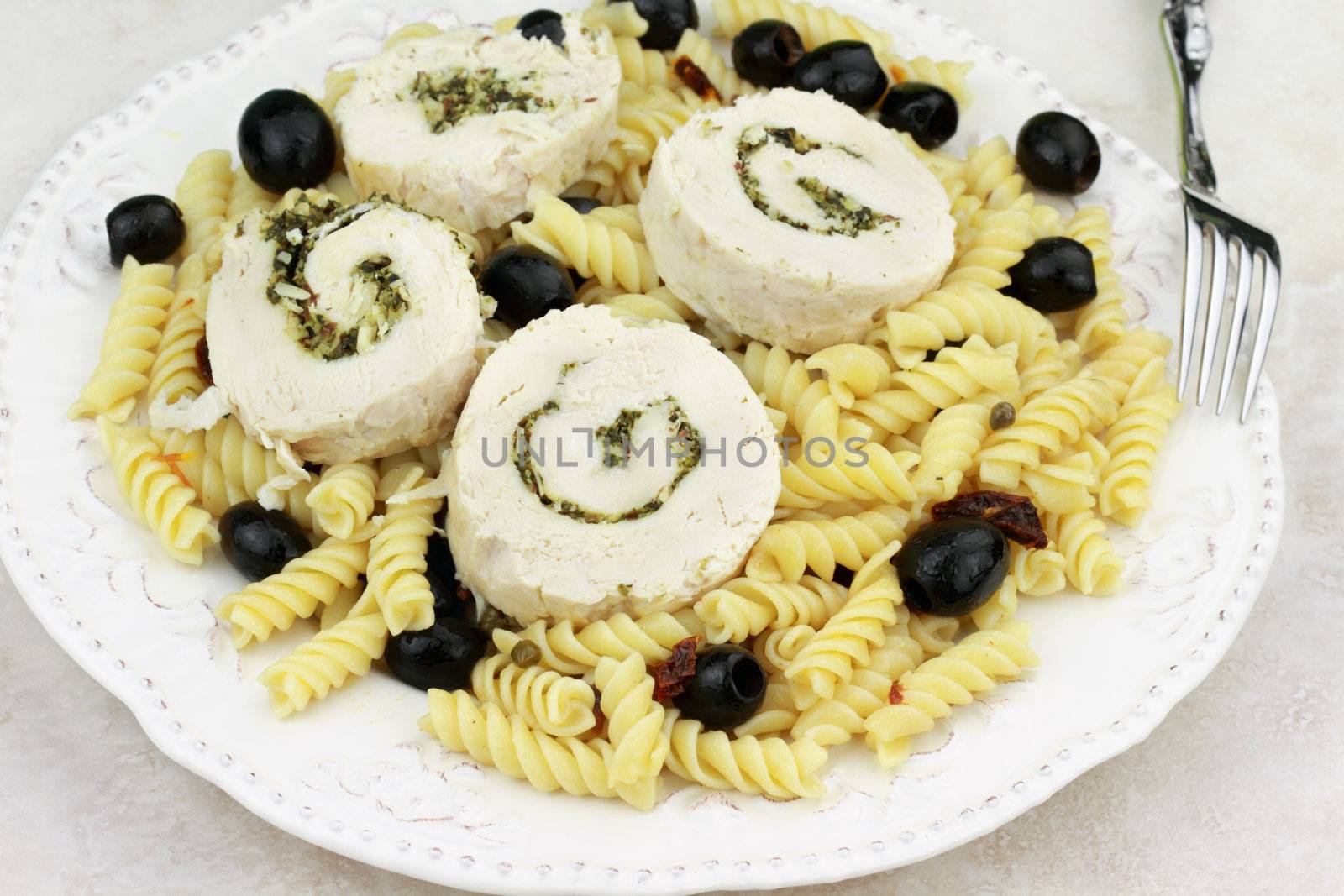 Steamed Chicken Roulade stuffed with fresh chopped basil leaves and nuts. Served over Italian rotini pasta with dried tomatoes and olives. 