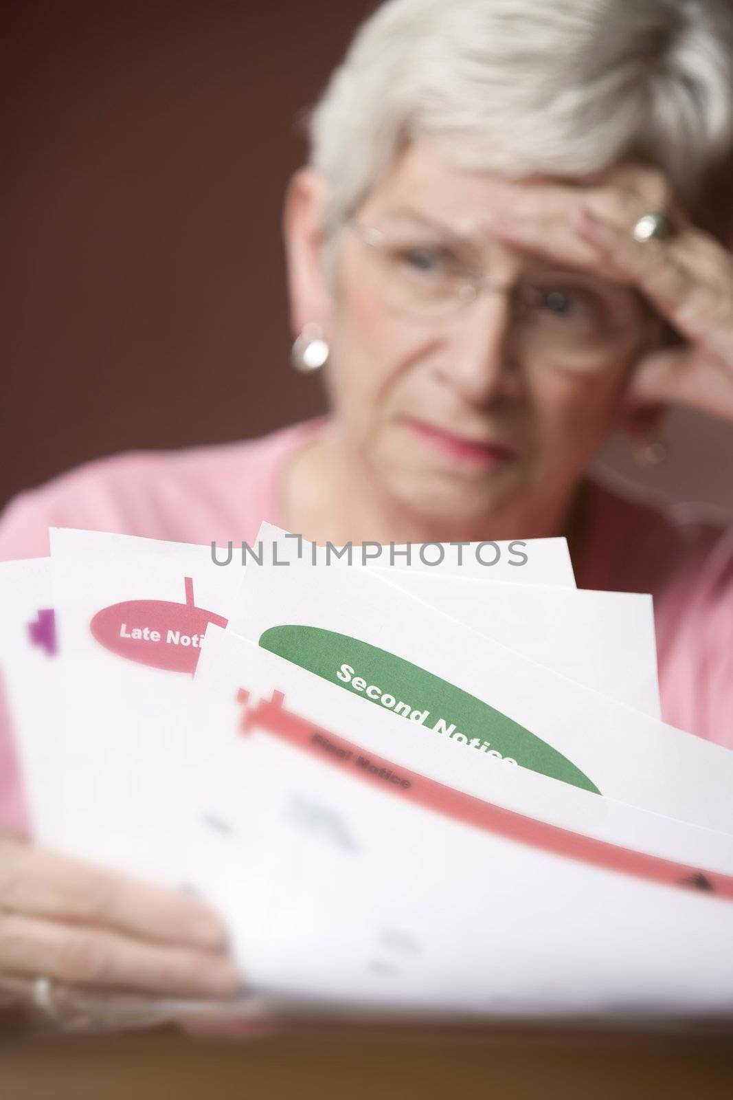 Upset senior woman with many bills and notices