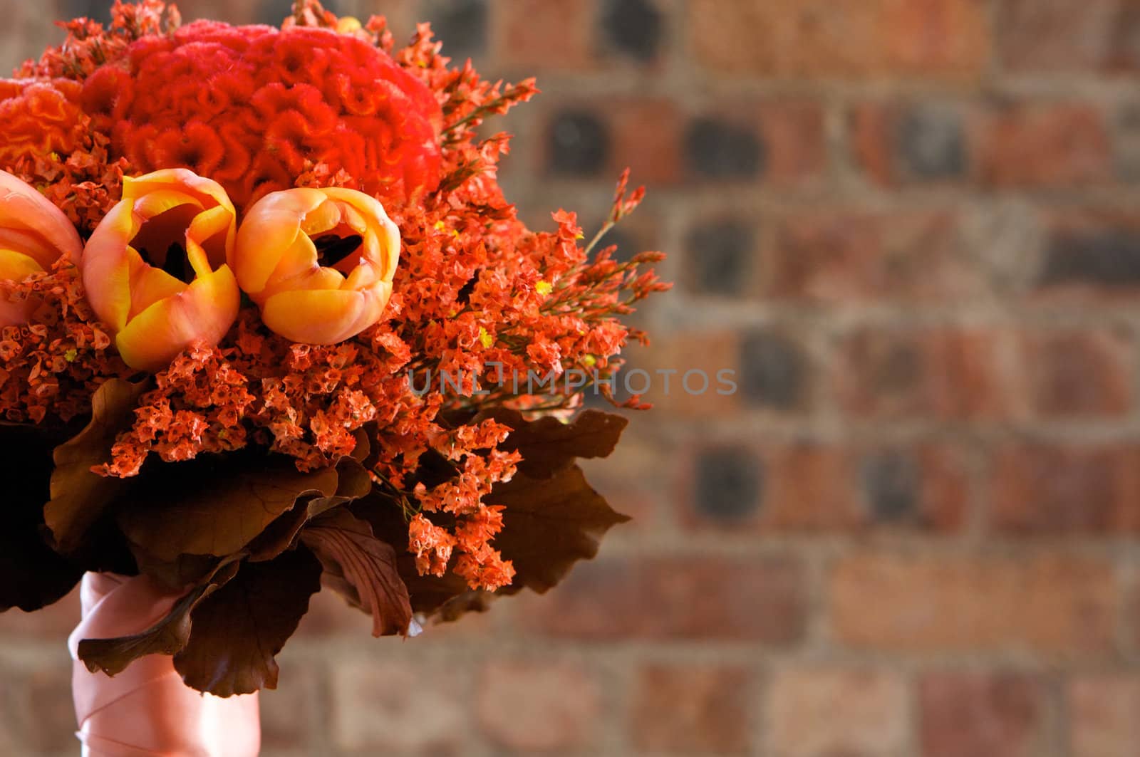 A colorful red and orange bridal bouquet of flowers