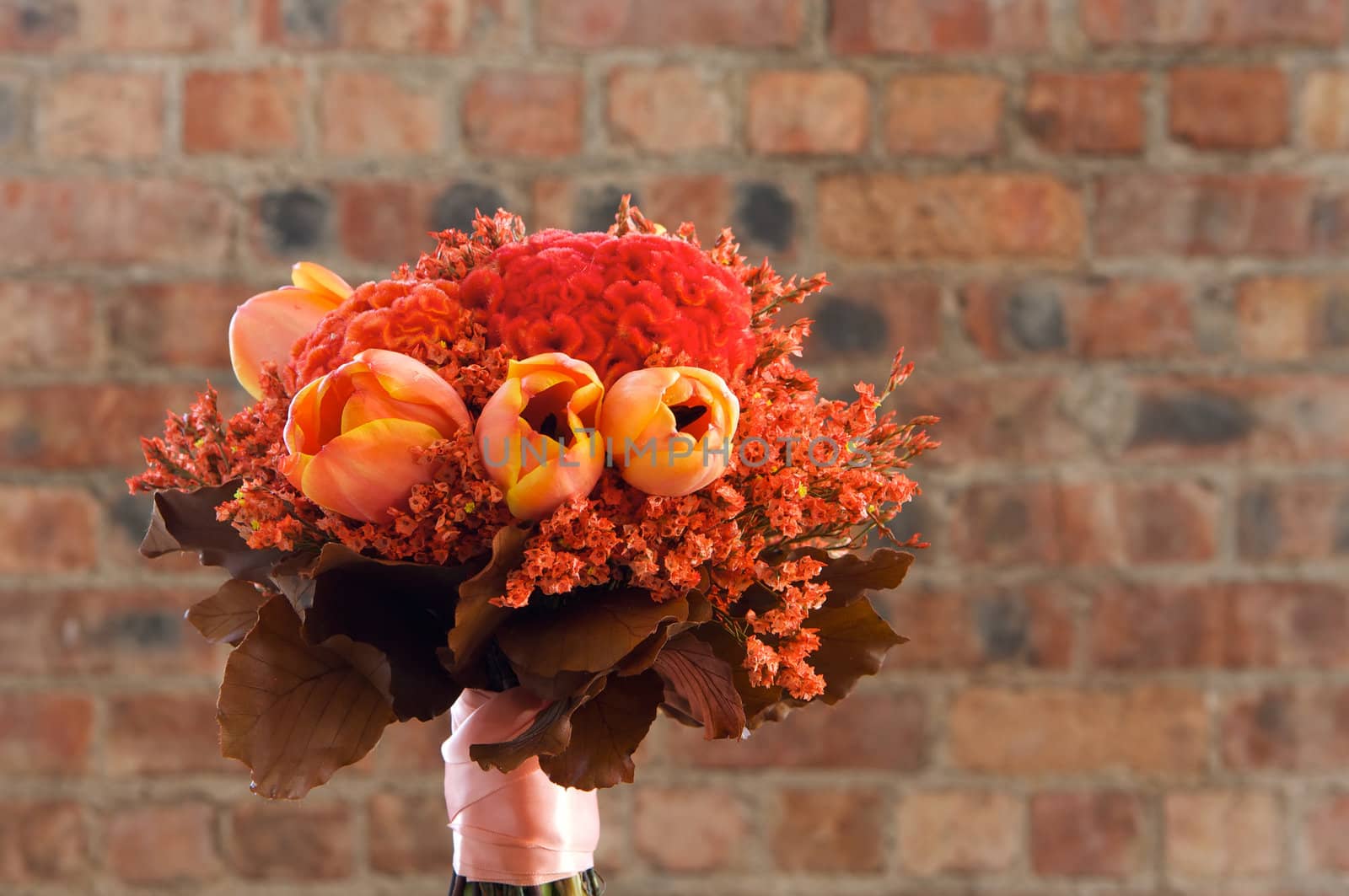 A colorful red and orange bridal bouquet of flowers