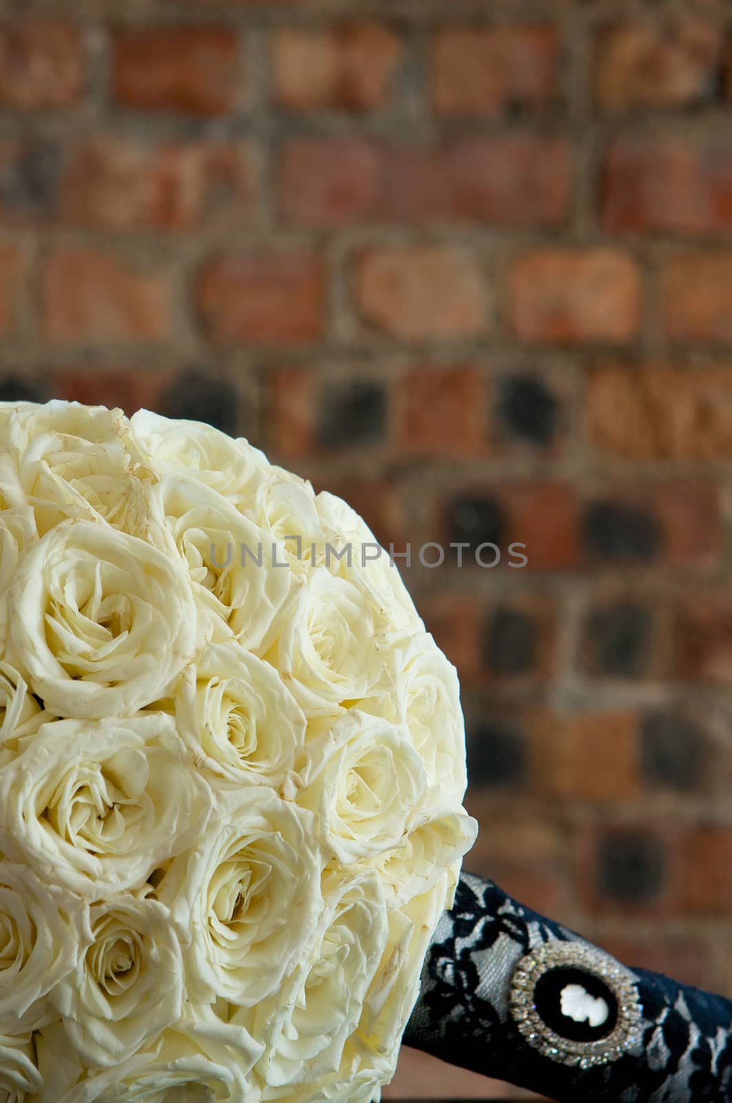 A bridal bouquet of flowers made with cream colored roses