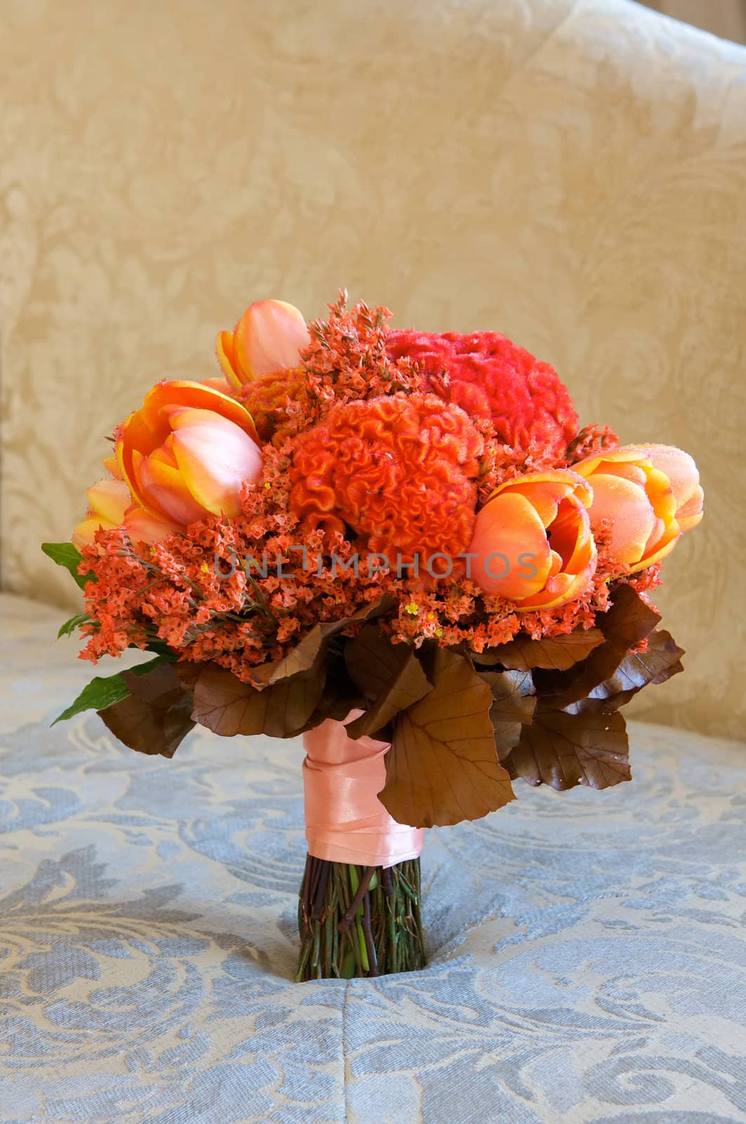 A colorful red and orange bridal bouquet of flowers by Deimages