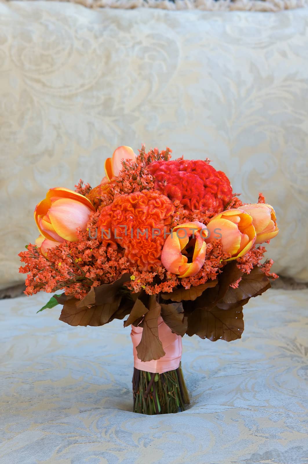 A colorful red and orange bridal bouquet of flowers by Deimages