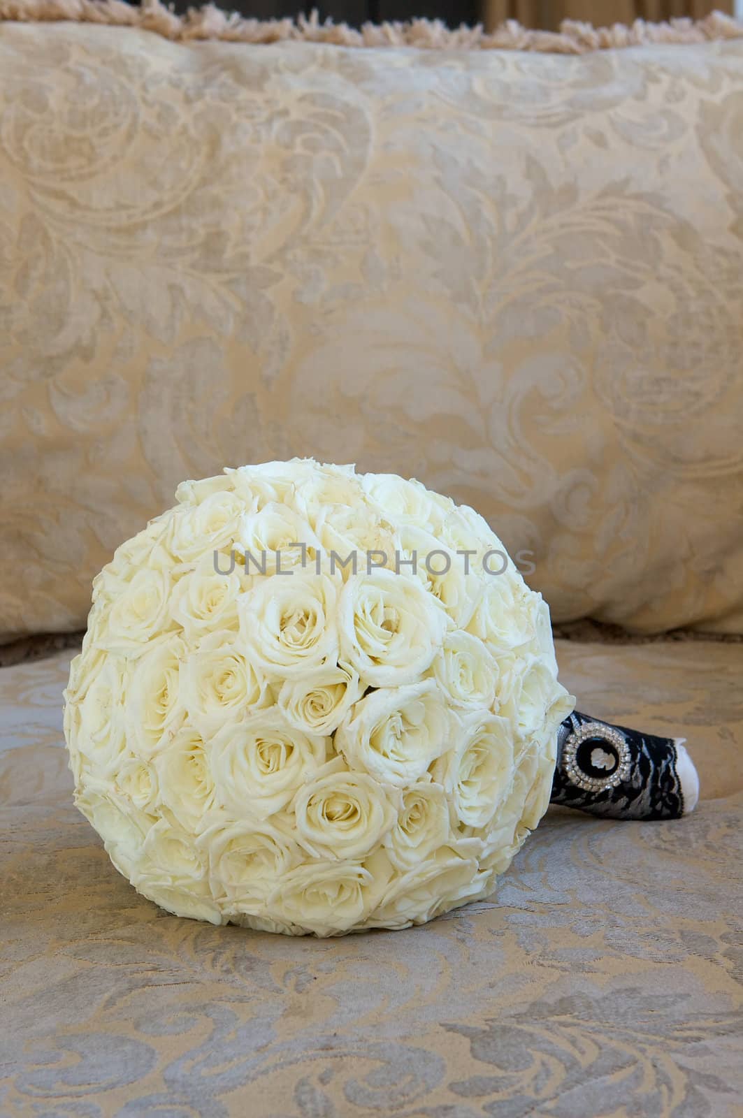 A bridal bouquet of flowers made with cream colored roses