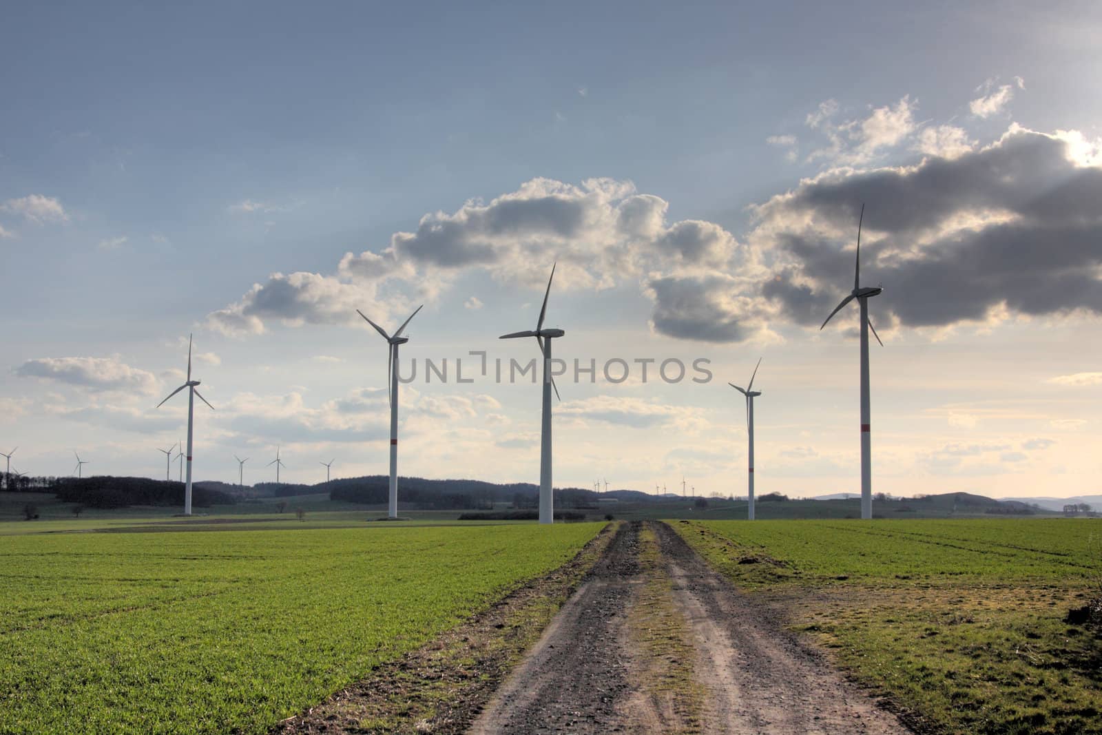 wind turbines near a dirt road in rural german landscape