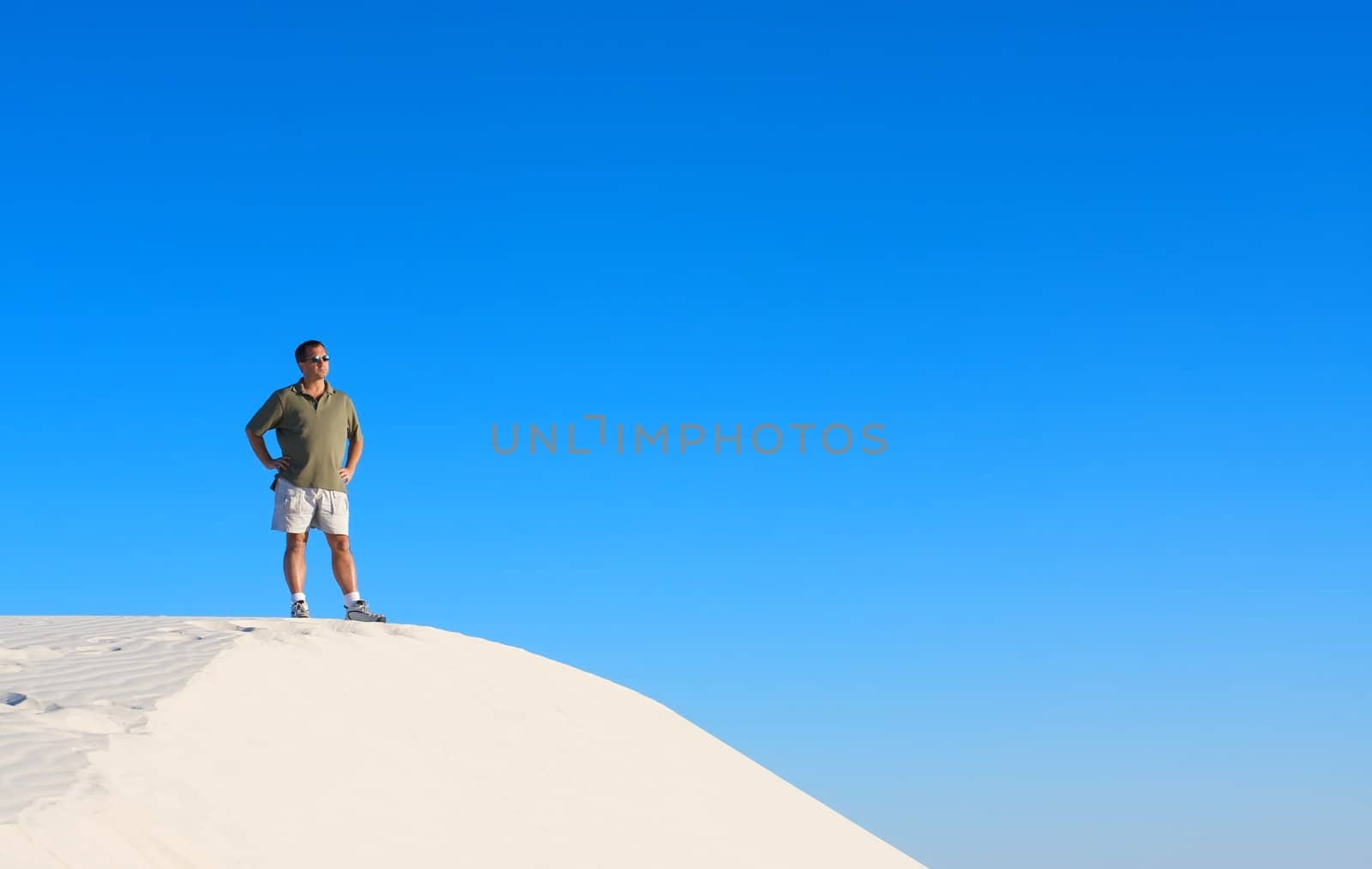A man atop a sand dune by Deimages