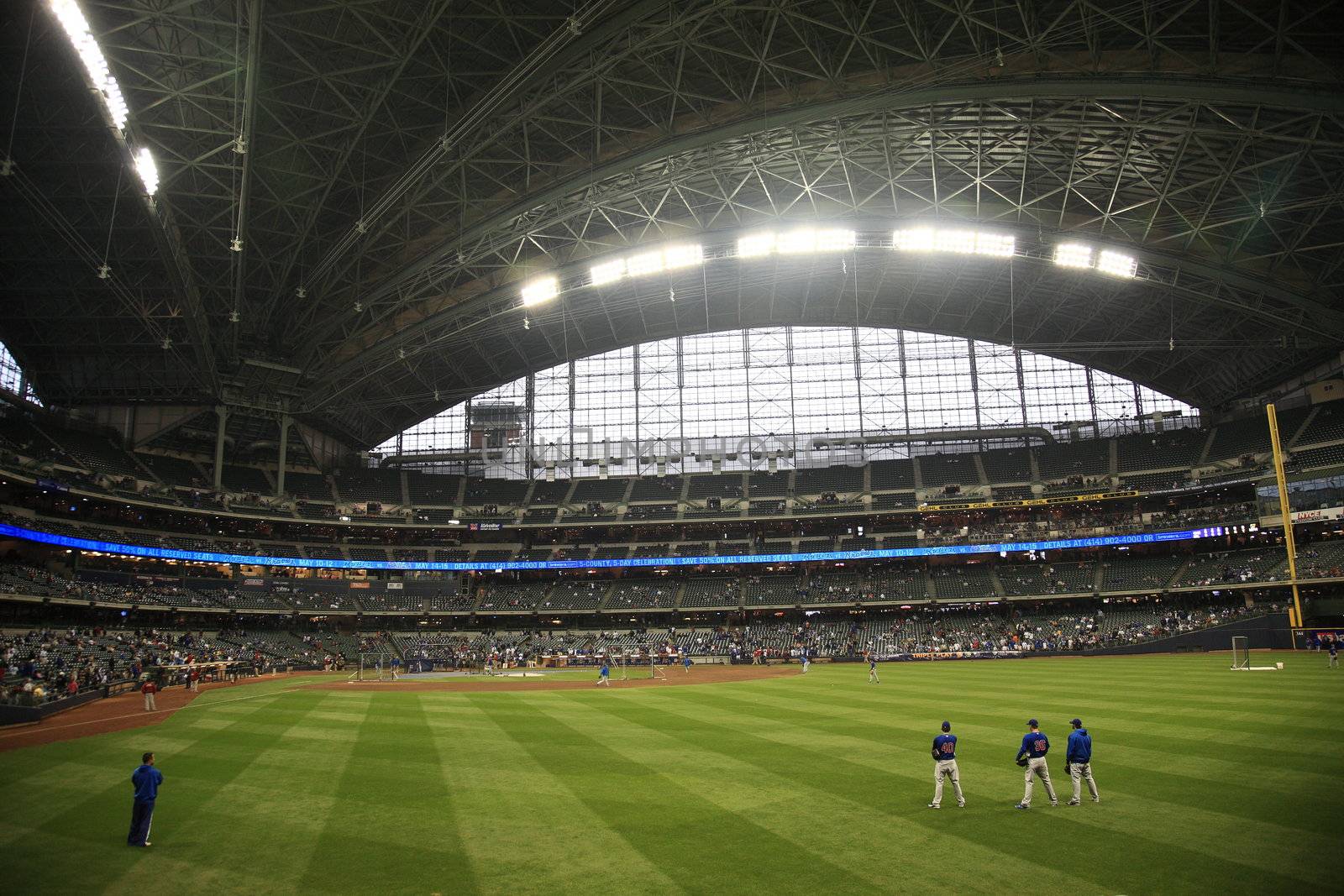 Baseball players conduct batting practice under a closed dome