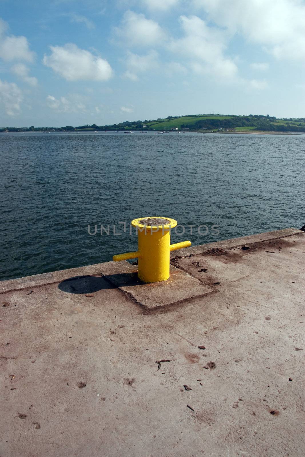 a yellow bollard on an irish quay