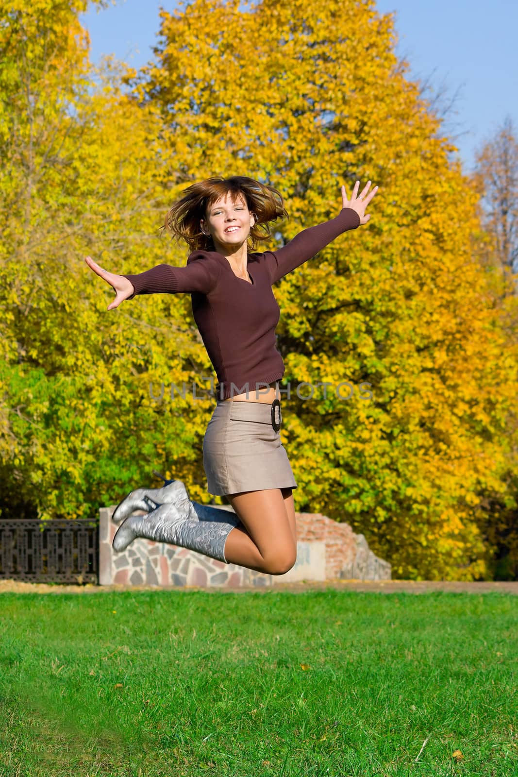 The nice jumping girl against the autumn nature