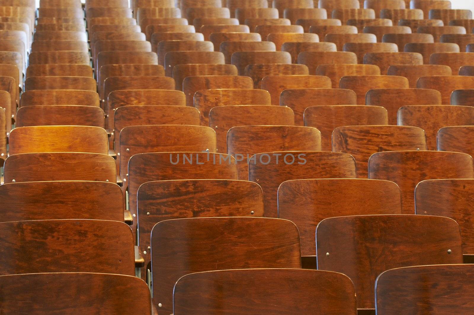 rows of wood chairs in an old auditorium
