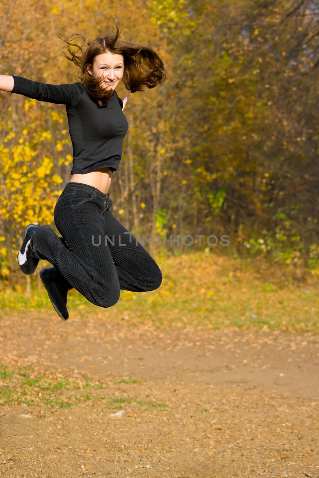 The jumping girl against the autumn nature
