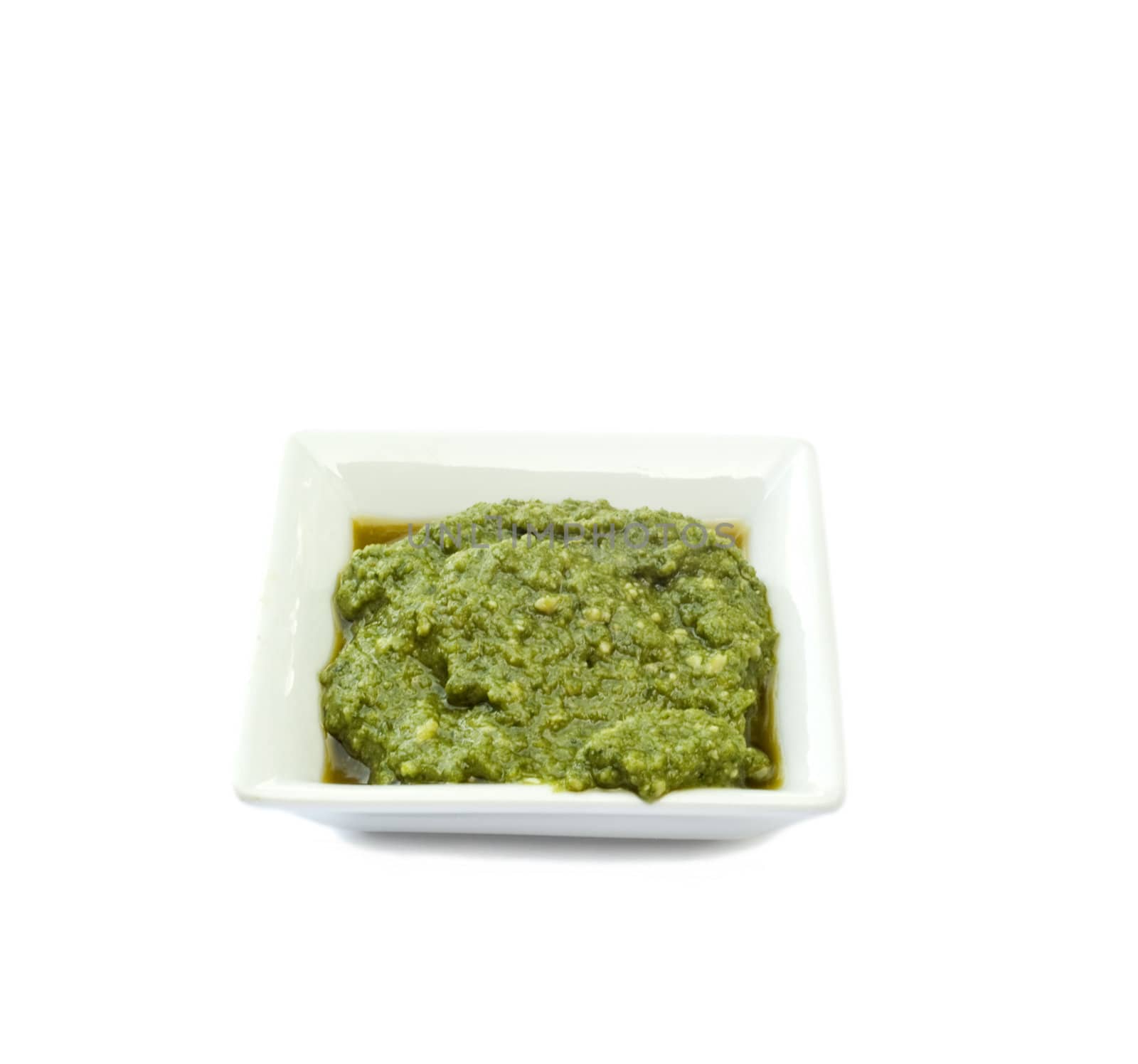 cup basil sauce on a white background