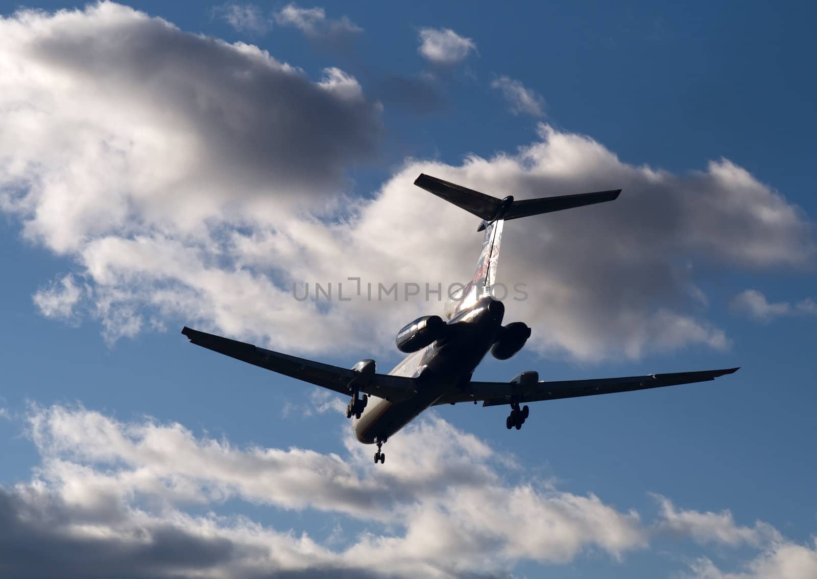 Passenger airplane landing in sunset beams