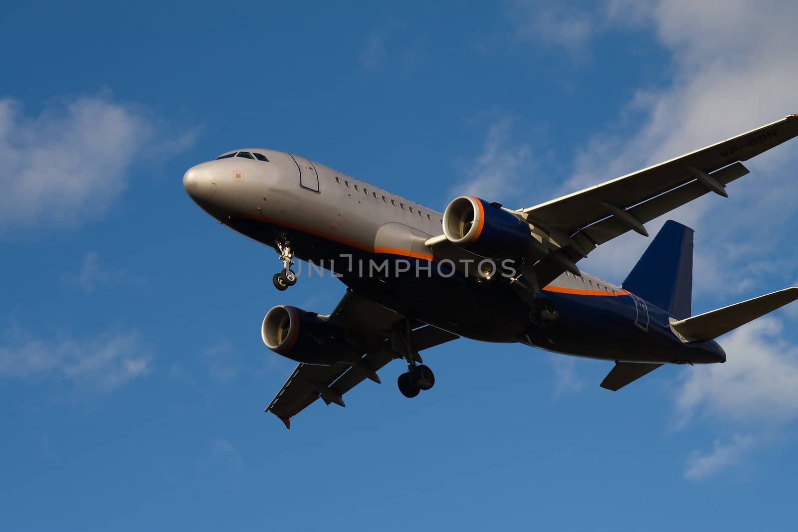 Passenger jet flying in blue sky with clouds