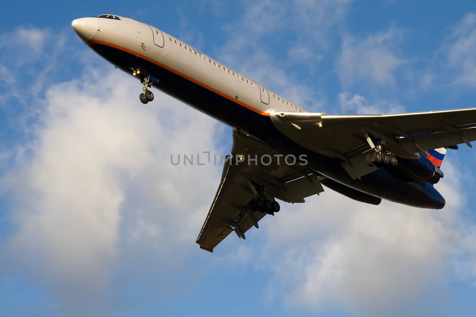 Passenger airplane taking off in blue sky with clouds