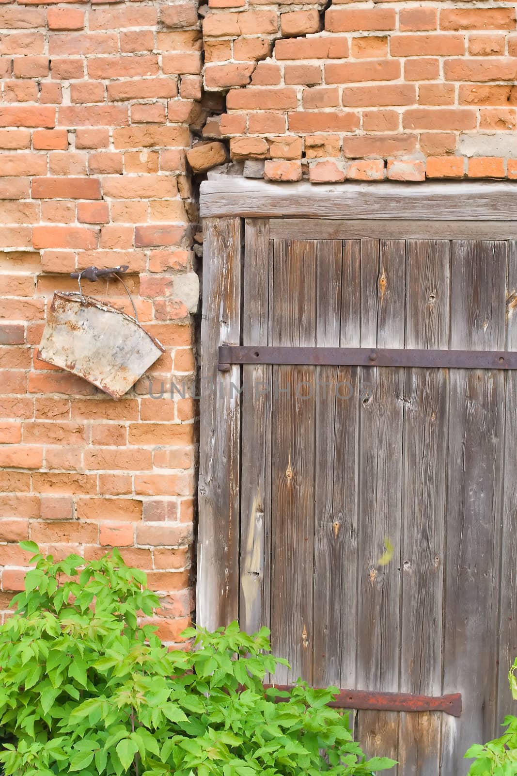 Old brick wall with wooden door by serpl
