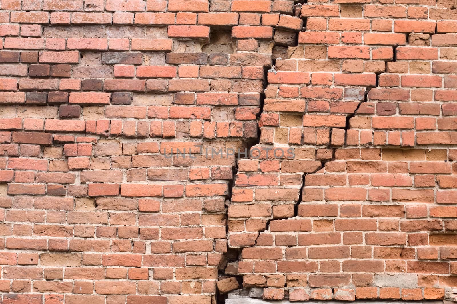 Old red brick wall with cracks