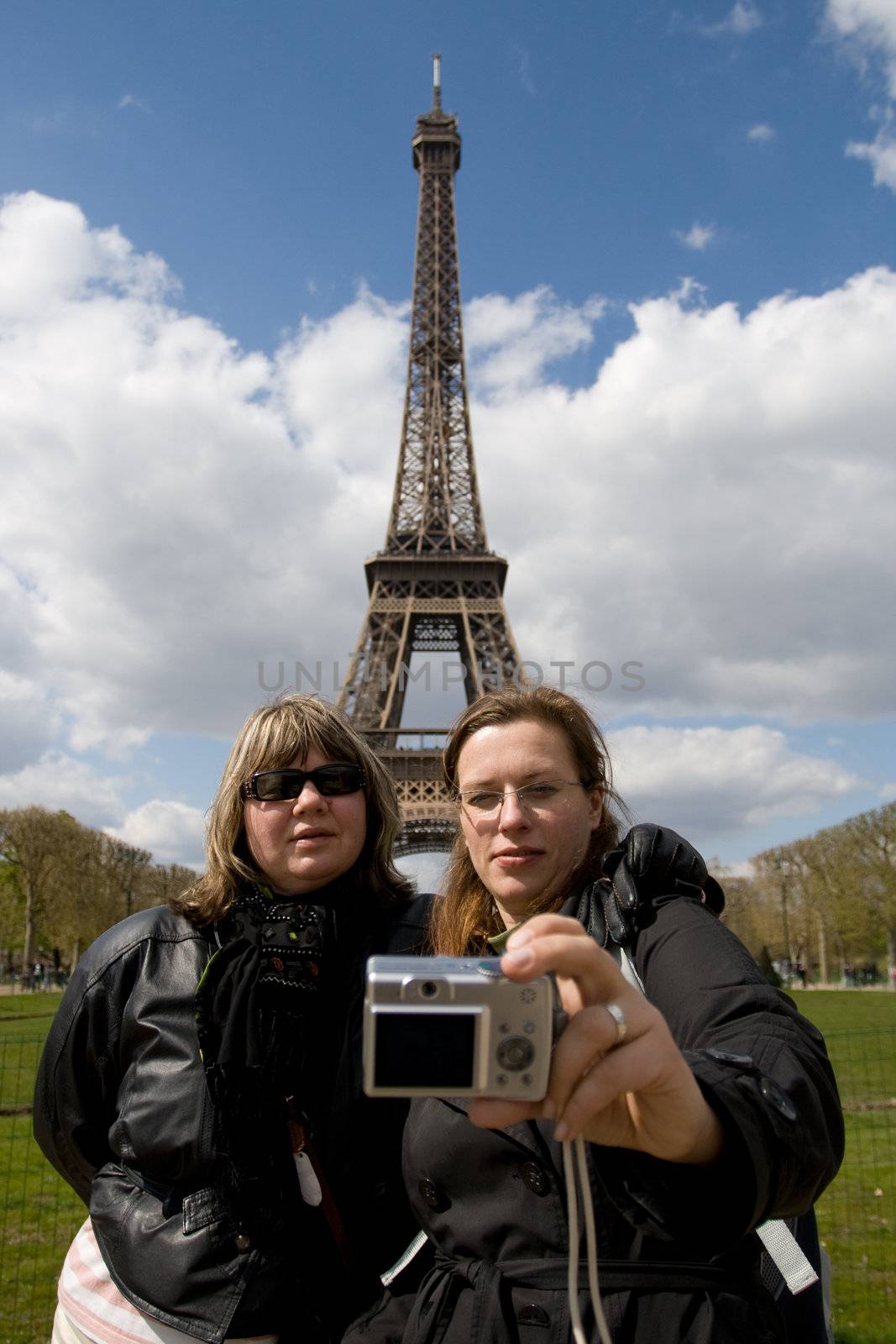 Group of tourists taking self portrait at the famous Eiffel tower in Paris